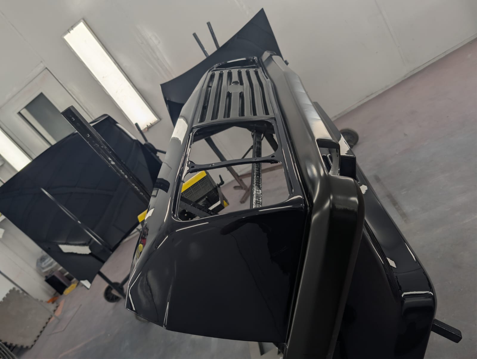 Freshly painted gloss black panels on stands in the booth