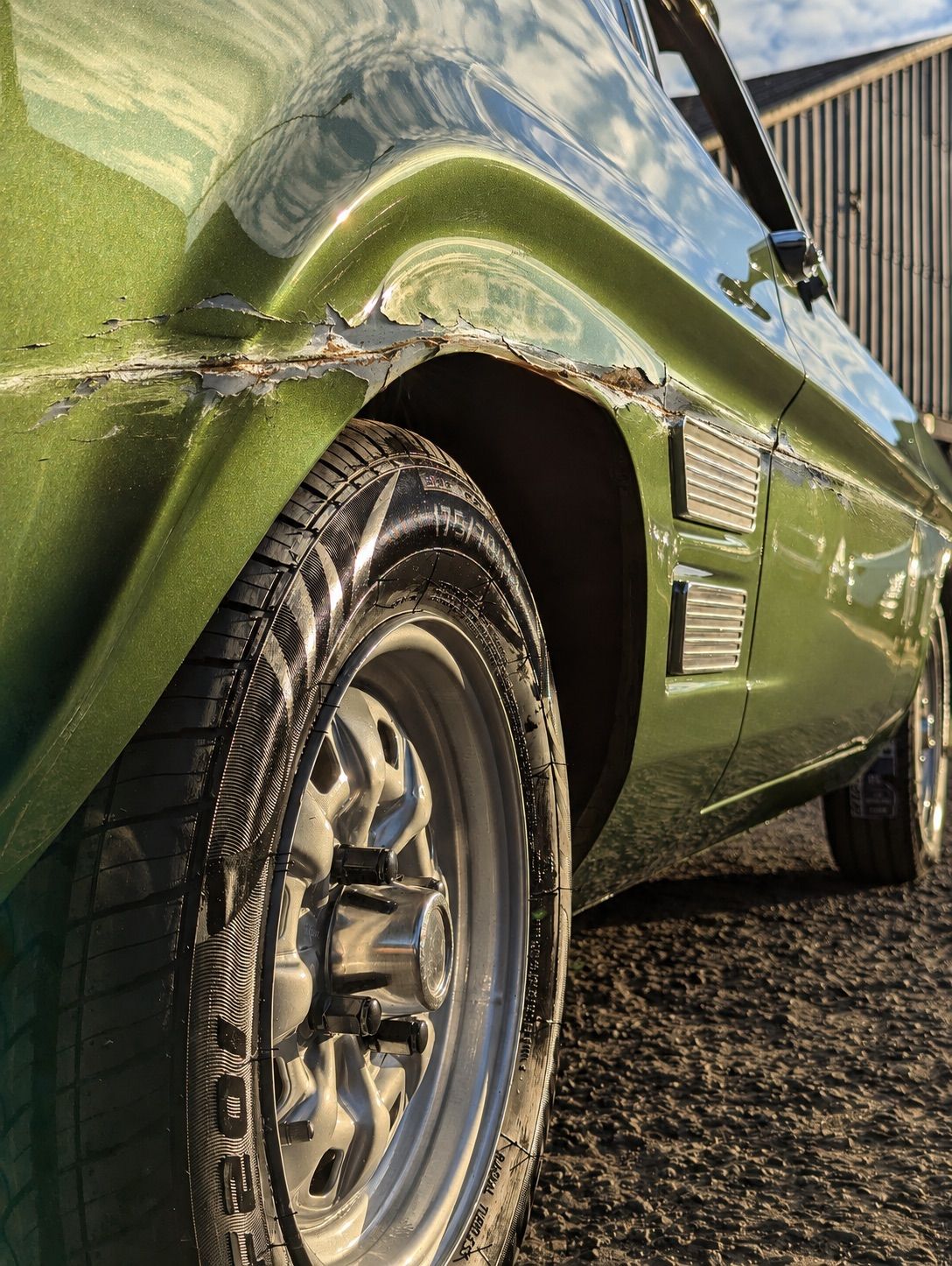 The same Capri wing as it arrived: stone chips and scuffed paint across the arch
