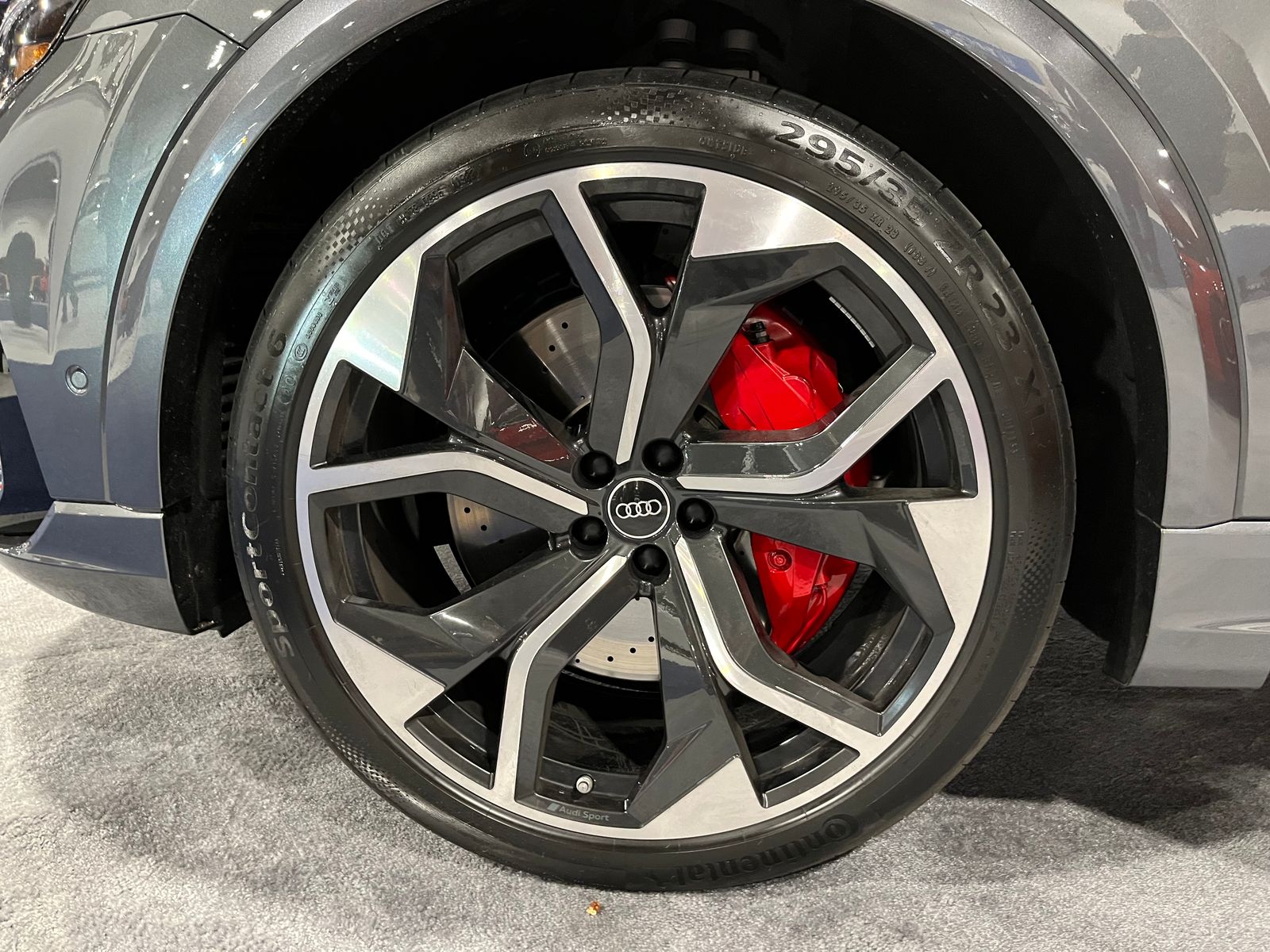 A diamond-cut two-tone Audi alloy with a red brake caliper, close up