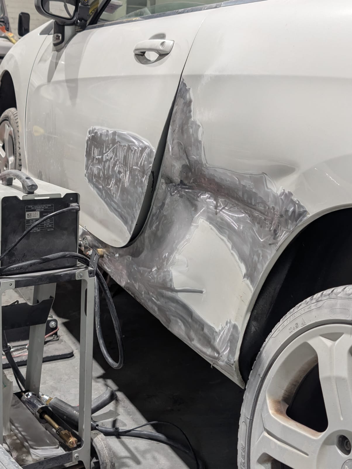 A door and rear quarter worked back to bare metal before filler and paint
