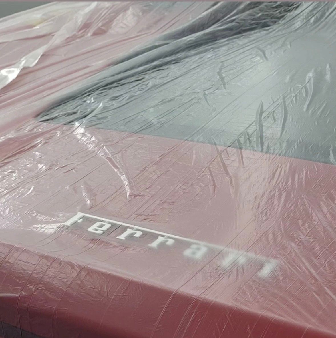 A Ferrari masked up for refinishing in the booth