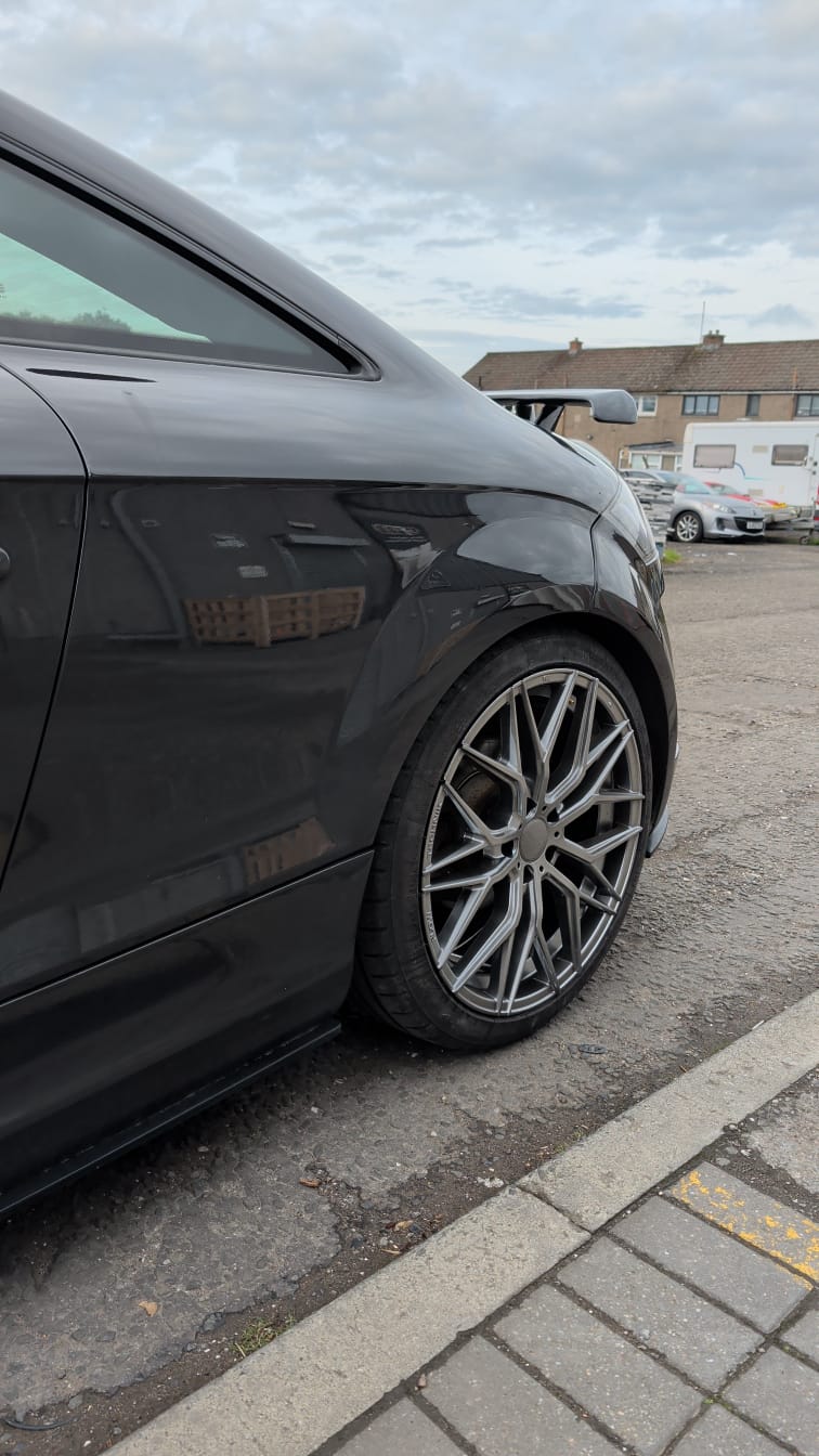 A lowered black Audi TT on gunmetal aftermarket alloys