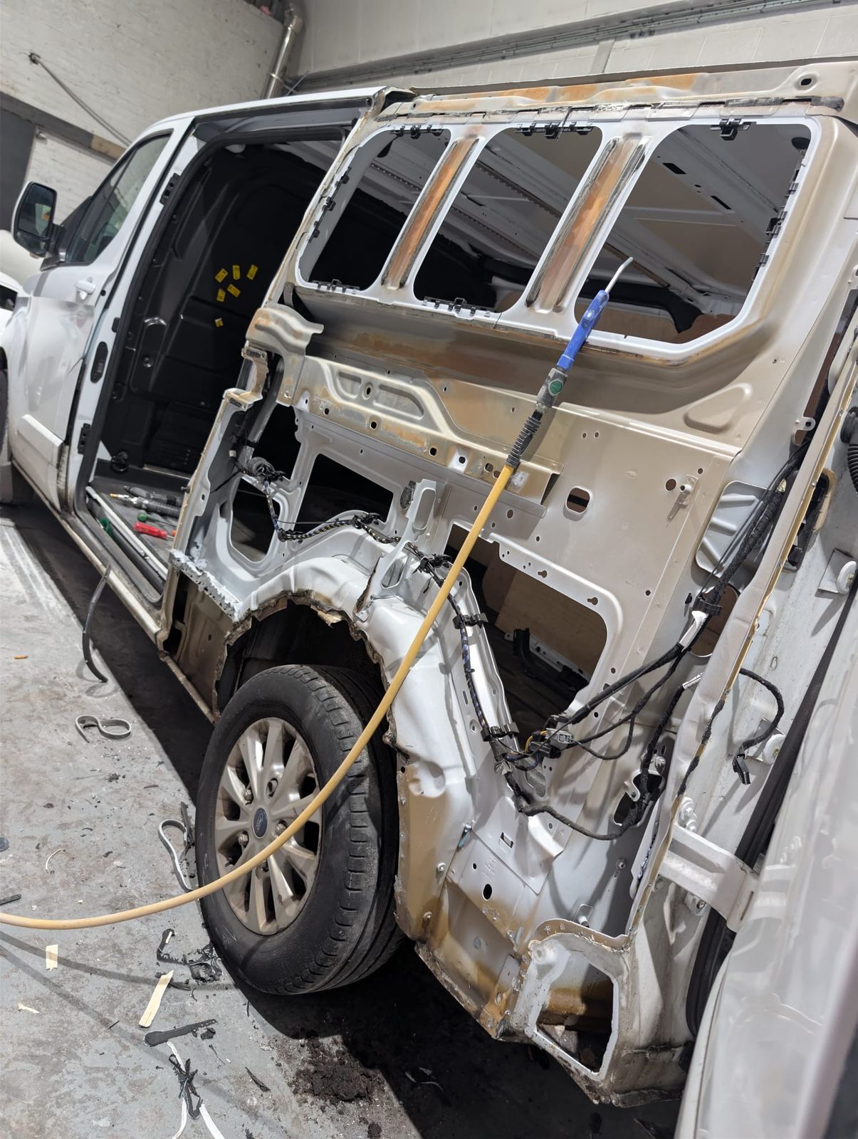 A van stripped back to bare metal mid structural repair in the Rewind bay